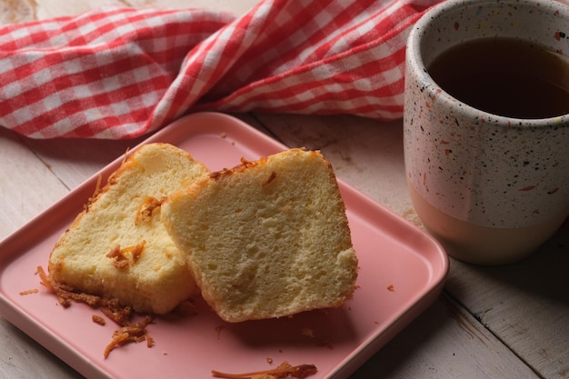 Un piatto rosa con pane e una tazza di tè sopra chiffon cake tea time