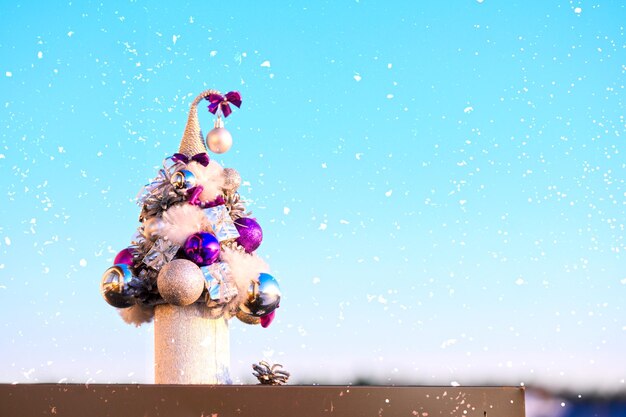 Un piccolo albero di natale decorato decorativo sullo sfondo del cielo foto di alta qualità