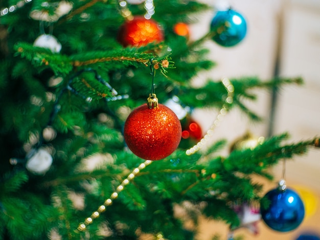 Un piccolo albero di natale in un vaso decorato con ghirlande di palline