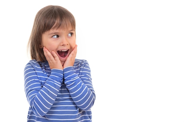 Un piccolo bambino felice con la bocca aperta distoglie lo sguardo sorpreso su uno sfondo bianco