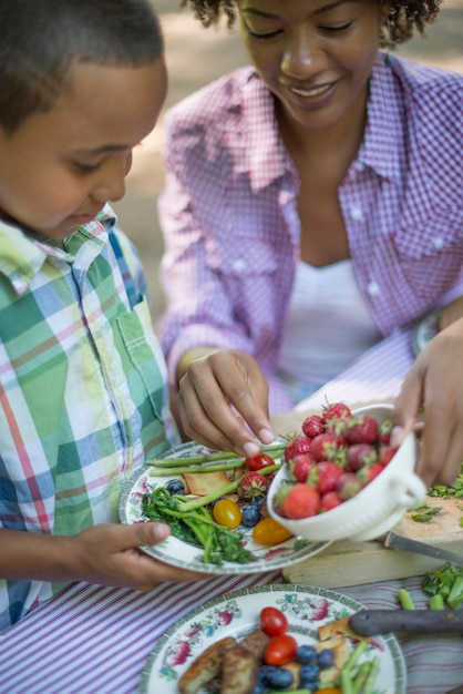 Un picnic in famiglia all'ombra di alberi ad alto fusto Madre e figlio fianco a fianco