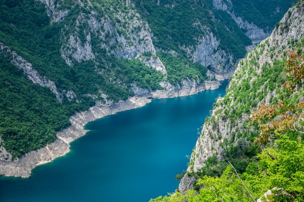 Un pittoresco lago turchese può essere visto dalla cima di un'alta montagna