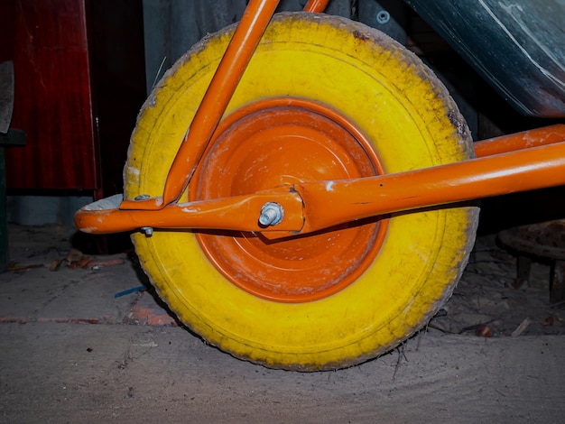 Un pneumatico giallo su una ruota del carrello da giardino