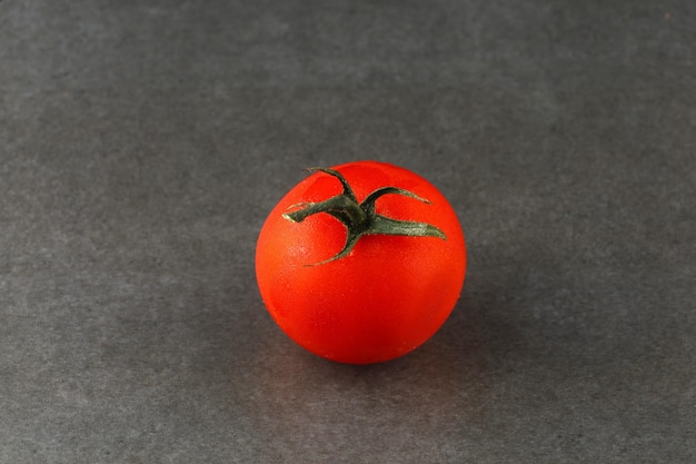 Un pomodoro rosso su sfondo grigio