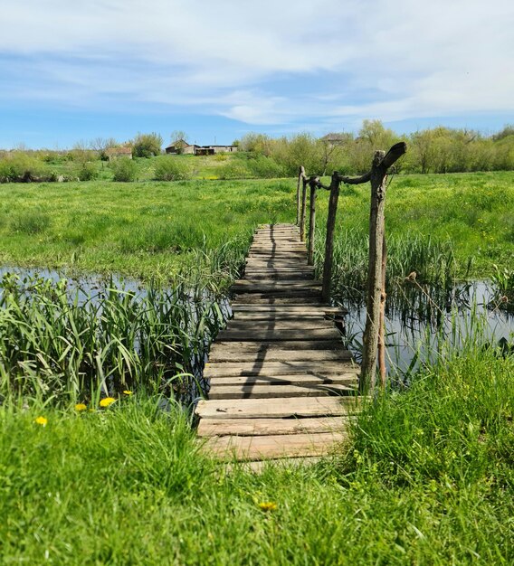 Un ponte di legno sopra un laghetto con un cartello che dice "la parola".