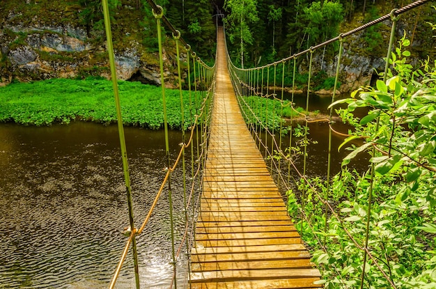 Un ponte sospeso in legno sul fiume.