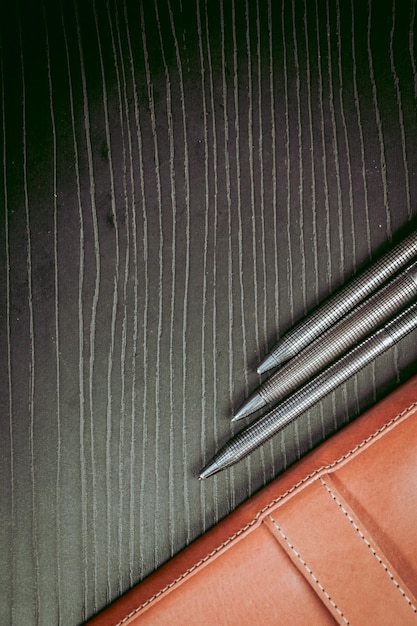 Un portafoglio di pelle nera con sopra una penna