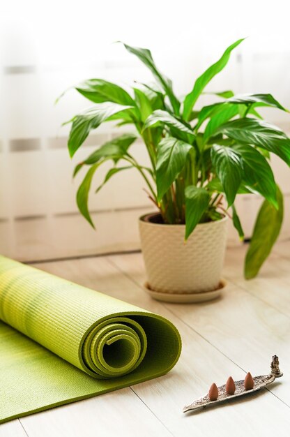 Un posto dove praticare yoga a casa un tappetino da yoga e bastoncini di incenso per la meditazione e il relax