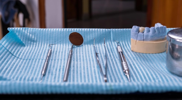 Un primo piano del vassoio degli strumenti dentali disposto in un ordine ordinato pronto per l'uso in uno studio dentistico o in una clinica