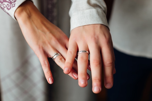 Un primo piano delle mani degli sposi sulle dita in cui il matrimonio