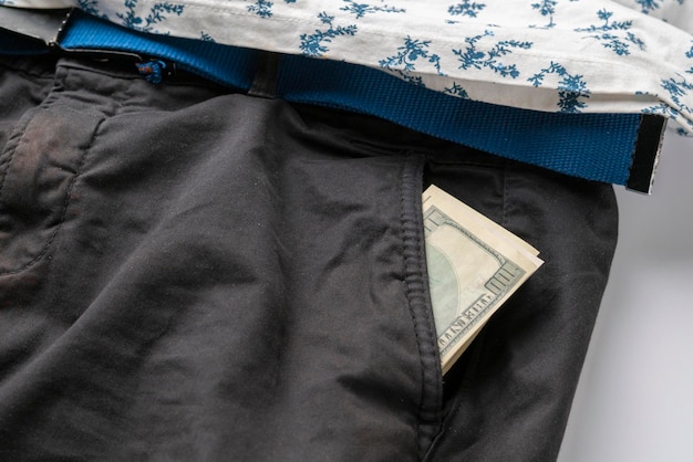Un primo piano di denaro contante in dollari nei guadagni di reddito dei pantaloni