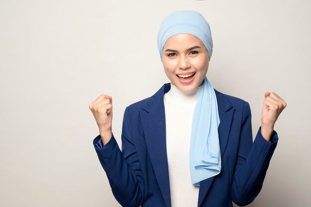 Un primo piano di giovane bella imprenditrice musulmana con hijab isolato sul muro bianco