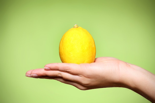 Un primo piano di un limone giallo su sfondo verde