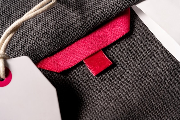 Un primo piano di un tag di tessuto rosso vuoto su un panno per un'etichetta di formato