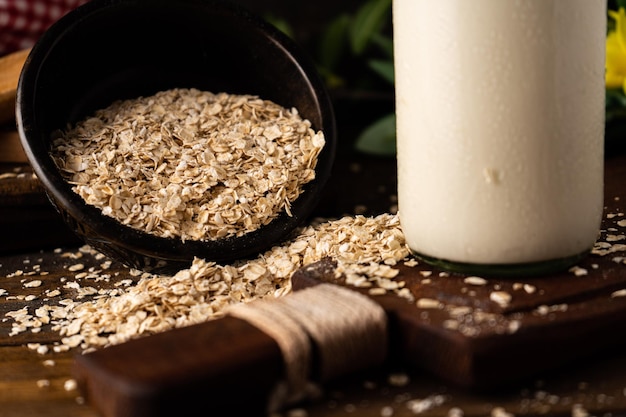 Un primo piano di una ciotola capovolta con farina d'avena accanto a una bottiglia su un tavolo da cucina