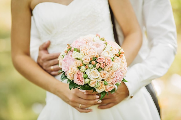 Un primo piano di una sposa in possesso di un bouquet