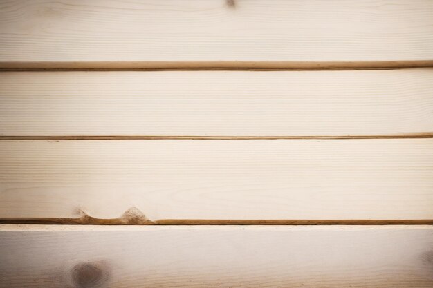 Un primo piano di una tavola di legno con una finitura di colore chiaro.