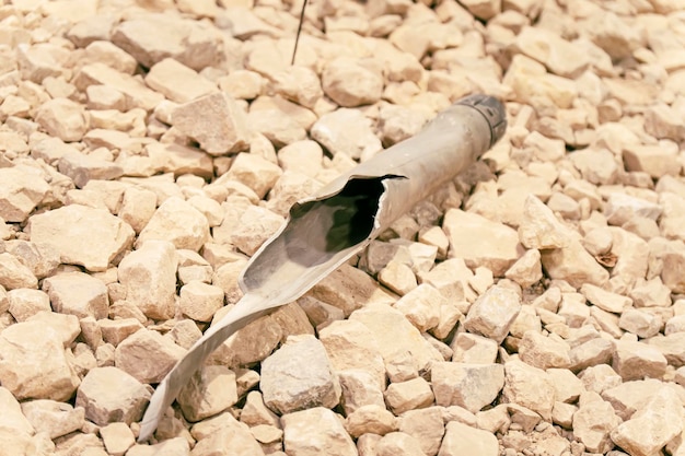 Un proiettile di artiglieria strappato sul terreno di pietra.