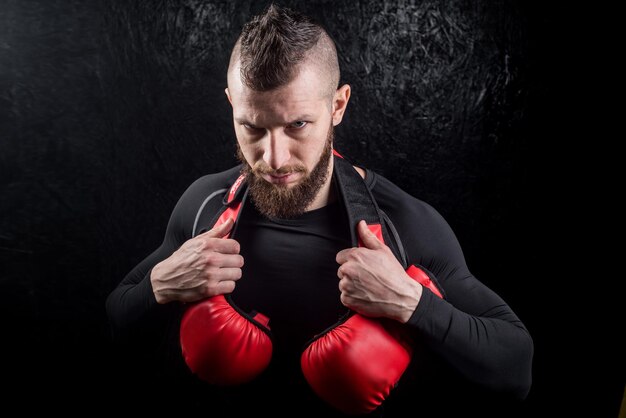 Un pugile che tiene i suoi bagliori su sholder dopo l'allenamento in palestra