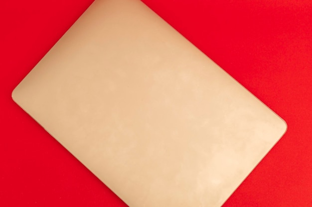 Un quaderno d'oro giace su uno sfondo rosso