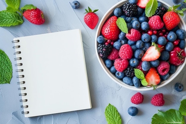 Un quaderno vuoto aperto e bacche e frutta colorate nella scatola da pranzo