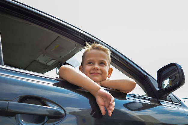 Un ragazzino affascinante guarda fuori dal finestrino dell'auto.