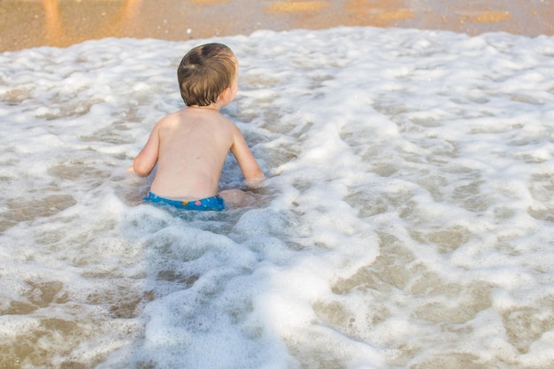 Un ragazzino che si diverte in mare sulle onde