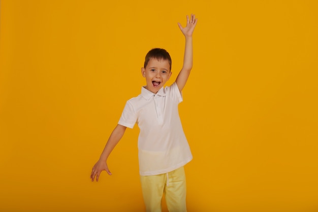 un ragazzino con una maglietta bianca e pantaloni gialli su sfondo giallo è un'emozione