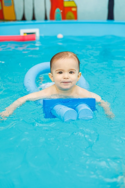 Un ragazzino di 2 anni è in piscina Lezioni di nuoto per bambini piccoli