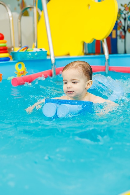 Un ragazzino di 2 anni è in piscina Lezioni di nuoto per bambini piccoli
