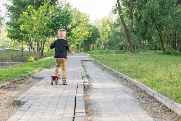 Un ragazzino di 35 anni sta guidando uno scooter in un parco con percorsi interrotti Lastra di pavimentazione rotta nel parco Povertà devastazione