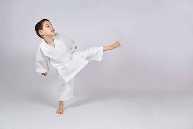 Un ragazzino in kimono si esercita nel karate