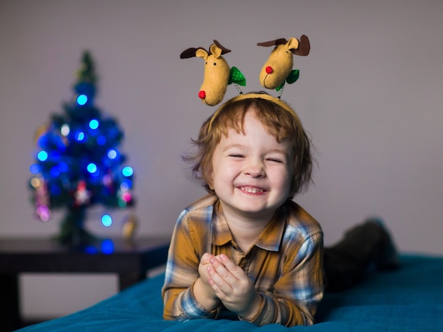 Un ragazzino indossa renne di Natale, il bambino è felice di festeggiare il Natale
