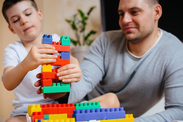 Un ragazzino insieme a suo padre è interpretato da un costruttore e costruisce una casa. Costruzione di una casa di famiglia.