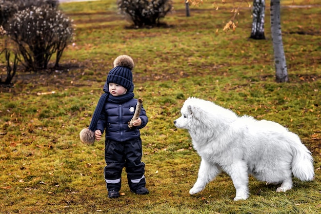 Un ragazzino si diverte a fare una passeggiata nel parco con il suo cane
