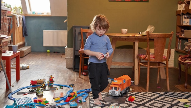 Un ragazzino sta giocando con i giocattoli nella stanza