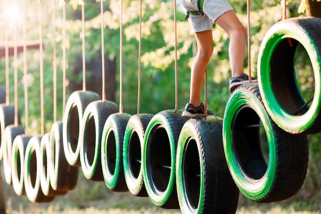 Un ragazzino supera l'ostacolo nel parco avventura