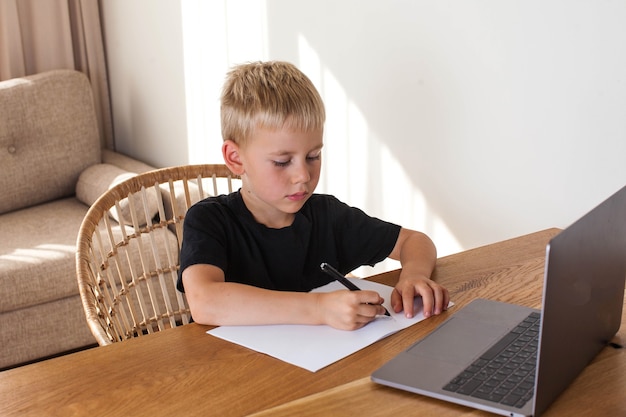 Un ragazzo biondo attinge da una lezione online.