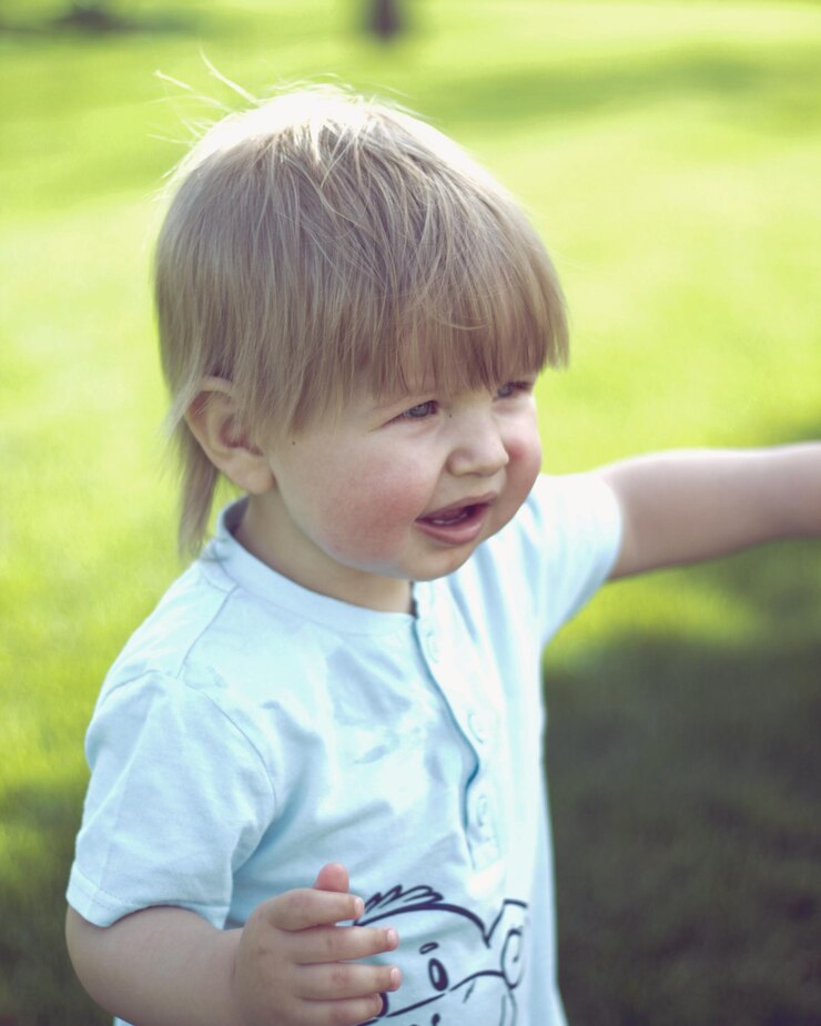 Foto un ragazzo carino che guarda lontano sul campo.