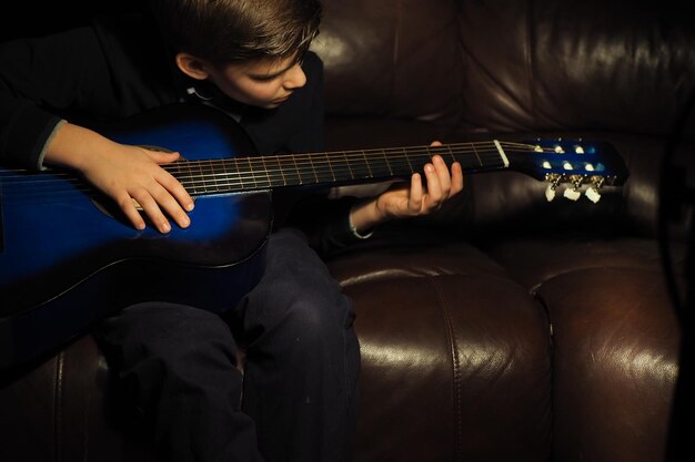 Un ragazzo che suona una chitarra su un divano