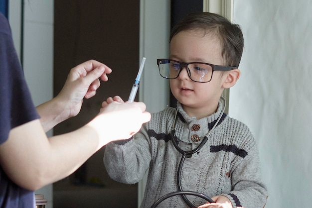 Un ragazzo con gli occhiali che tiene un ago nel suo