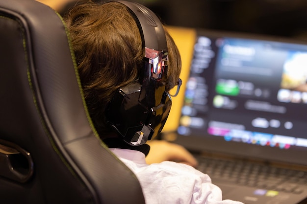 Un ragazzo con grandi cuffie che gioca usando il suo pc