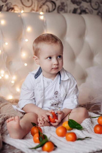 un ragazzo con i mandarini.Bambino di Capodanno. Natale. Mandarini