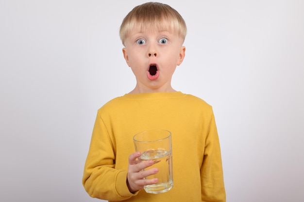 Un ragazzo con un bicchiere d'acqua in mano