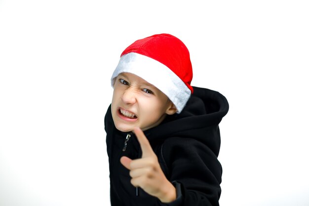 Un ragazzo con un cappello rosso piegato mostra il dito indice e minaccia che la telecamera mostri i denti