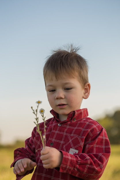 Un ragazzo con un mazzo di fiori tra le mani per la mamma.