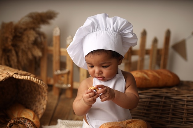 un ragazzo dalla pelle scura in costume da chef ha un bagel