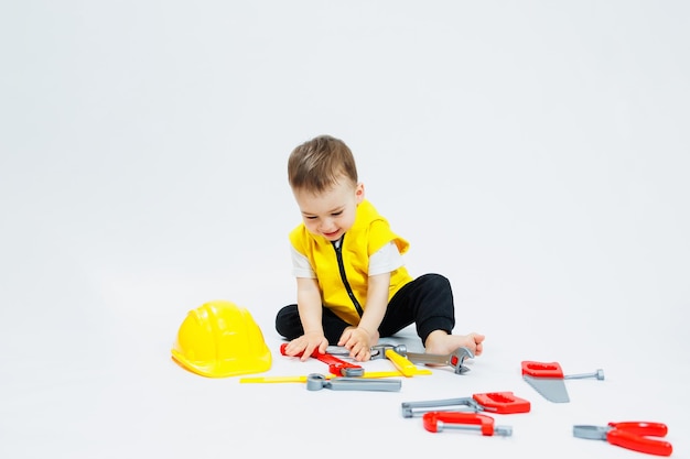 Un ragazzo di 2 anni gioca con strumenti di costruzione in plastica Giocattoli di plastica per bambini Set di costruttori per bambini