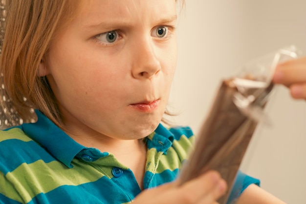 Un ragazzo di nove anni che mangia cioccolato.