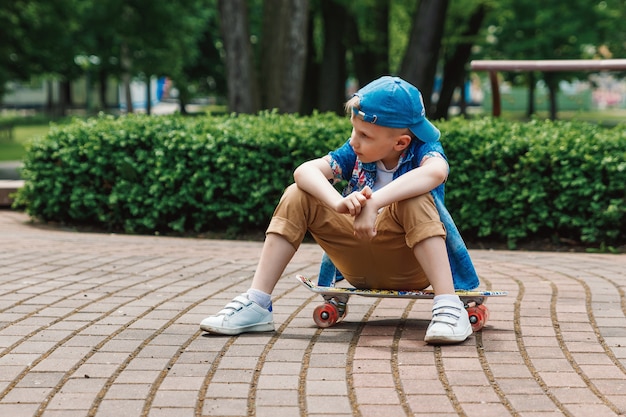 Un ragazzo di piccola città andskateboard. Un giovane ragazzo sta cavalcando uno skateboard parka